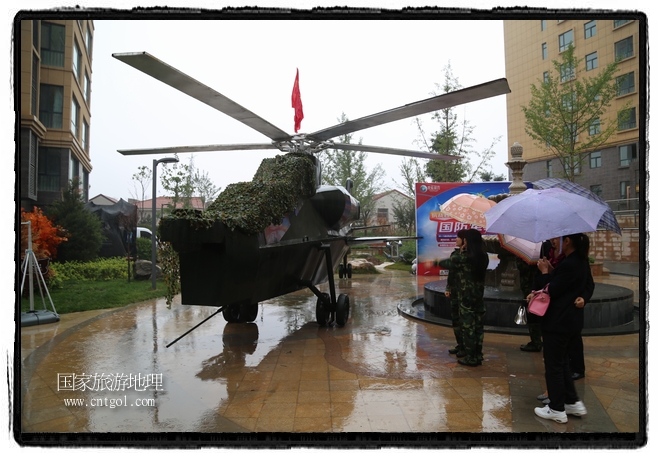 小區(qū)突然出現(xiàn)“飛機坦克”，其中殲15艦載戰(zhàn)斗機一架、99式主戰(zhàn)坦克一輛、武直-10武裝直升機一架，吸引了眾多市民雨中圍觀、合影。